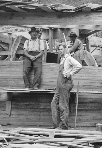 two men building a wooden structure in early 20th century